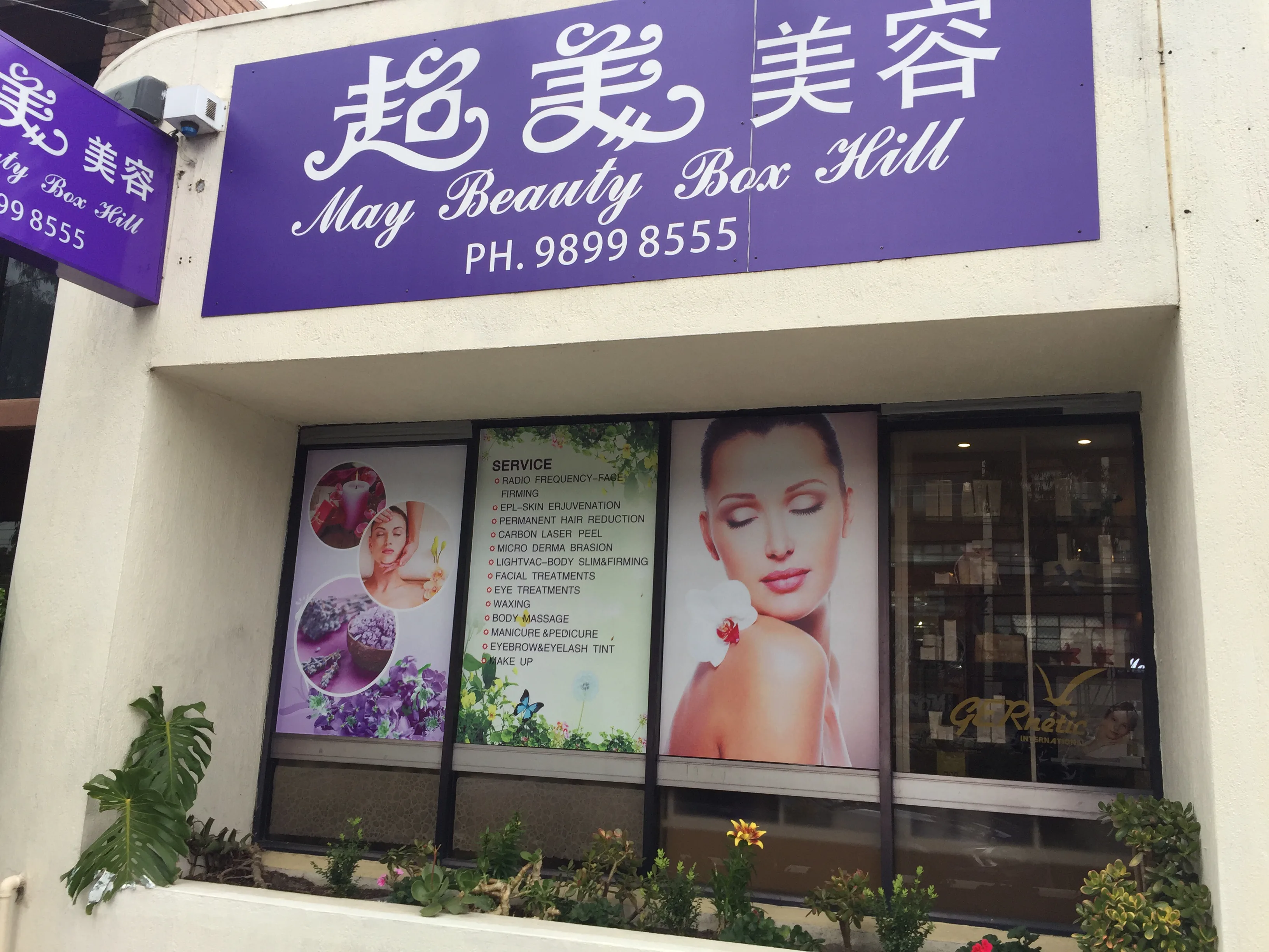 May Beauty Box Hill exterior — purple fascia signage on Rutland Road shopfront with garden bed and window service boards