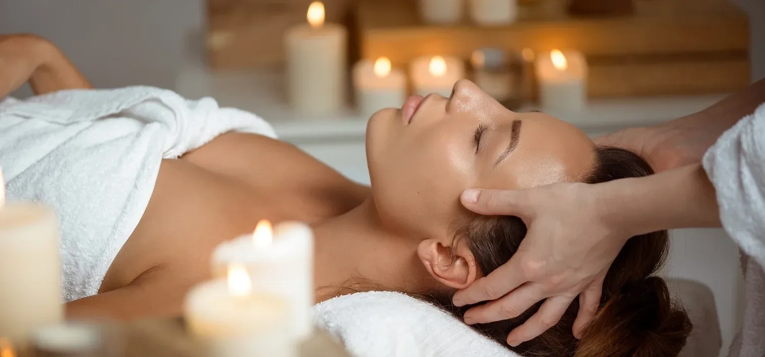 Therapist hands cradling a client's head in a calming facial massage